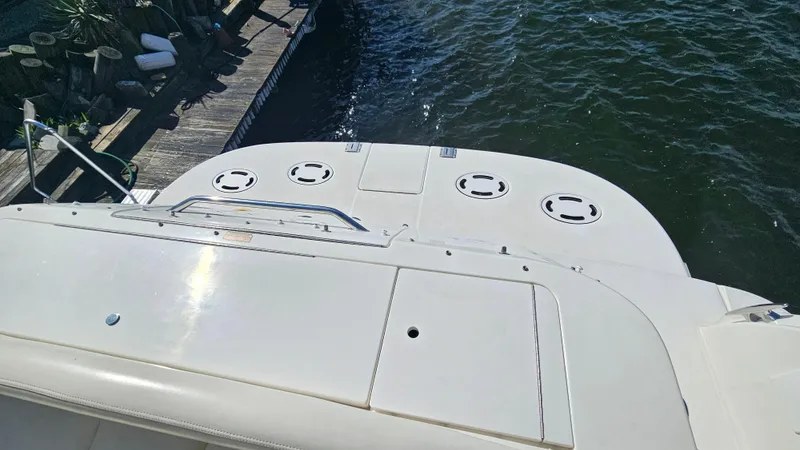 Slide: The Image of 2003 Sea Ray 410 Express Cruiser's deck by the water, showcasing sleek design. - 17