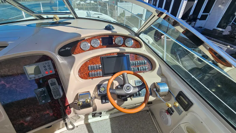 Slide: The Image of 2003 Sea Ray 410 Express Cruiser helm with wood accents and modern controls. - 26