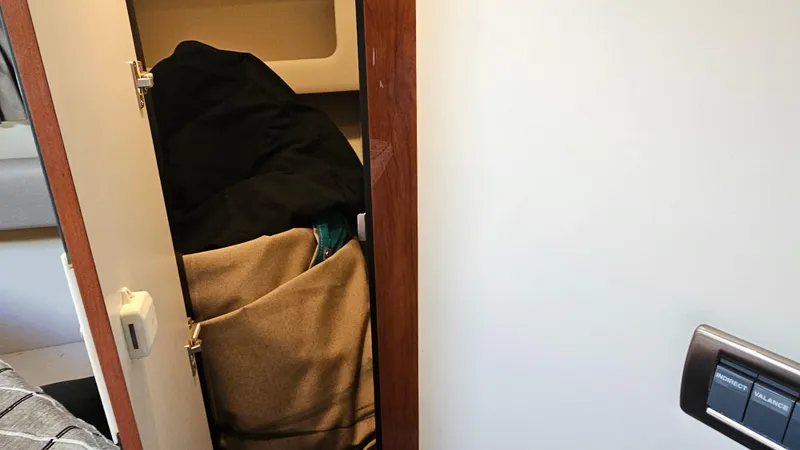 Slide: The Image of Interior storage area of a 2003 Sea Ray 410 Express Cruiser with clothes. - 44