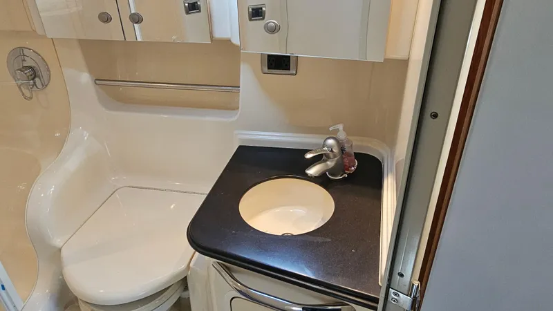 Slide: The Image of 2003 Sea Ray 410 Express Cruiser bathroom with sink, toilet, and storage cabinets. - 47
