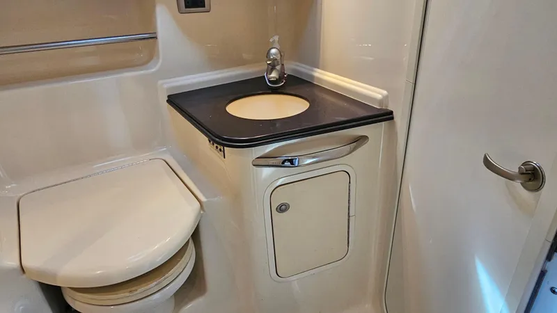 Slide: The Image of 2003 Sea Ray 410 Express Cruiser bathroom with sink, toilet, and storage cabinet. - 48