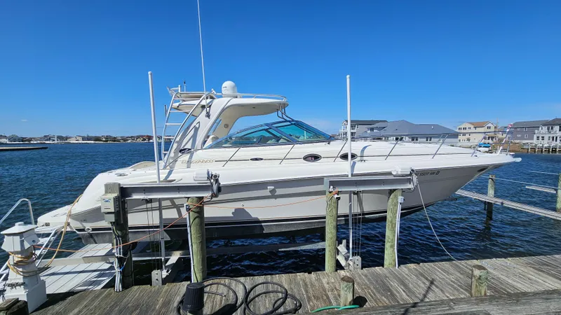 Slide: The Image of 2003 Sea Ray 410 Express Cruiser docked at a marina under clear blue skies. - 5