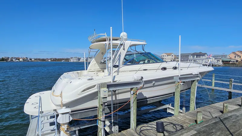 Slide: The Image of 2003 Sea Ray 410 Express Cruiser docked by waterfront homes. - 6
