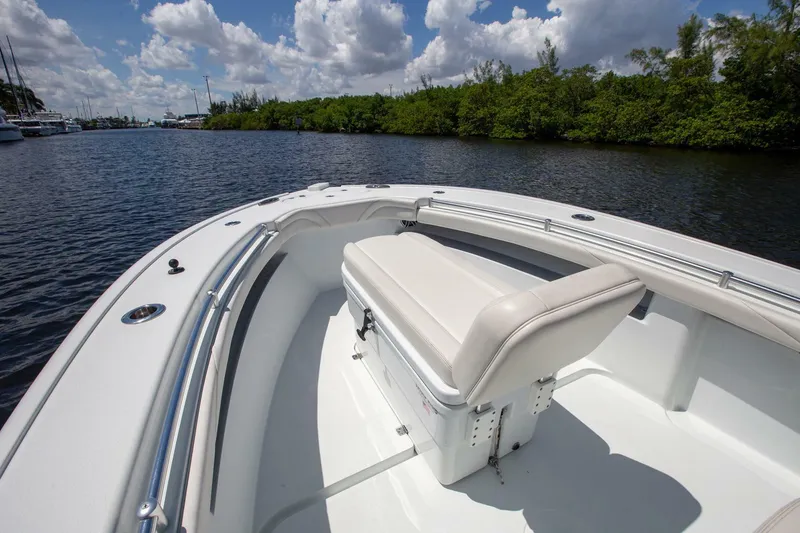 Slide: The Image of 2022 Yellowfin 26 Hybrid boat on calm water, featuring a sleek white deck and comfortable seating. - 5