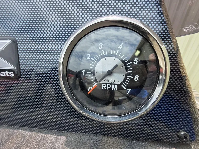 Slide: The Image of Tachometer of 2025 Xpress XP180 boat, displaying RPM on carbon fiber dashboard. - 17