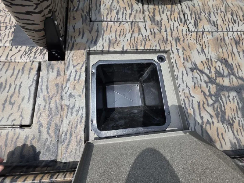 Slide: The Image of 2025 Xpress XP180 boat interior with open storage compartment, featuring camouflage design. - 6