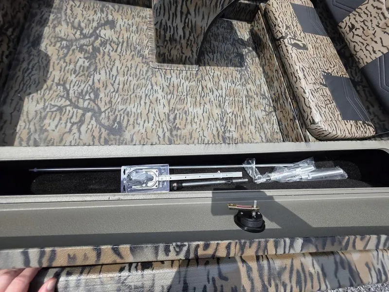 Slide: The Image of 2025 Xpress XP180 boat interior with camouflage seating and storage compartment. - 7