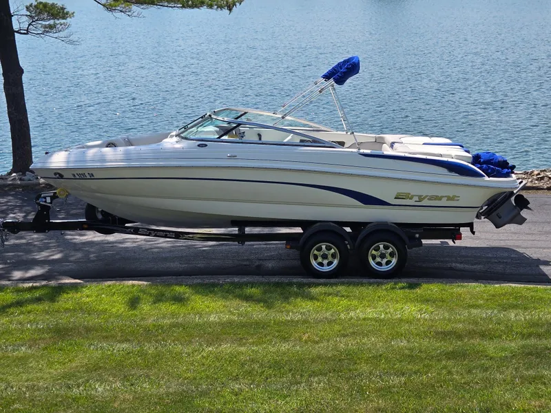 Slide: The Image of 2013 Bryant 210 STE boat on trailer by a lake, ready for transport. - 0