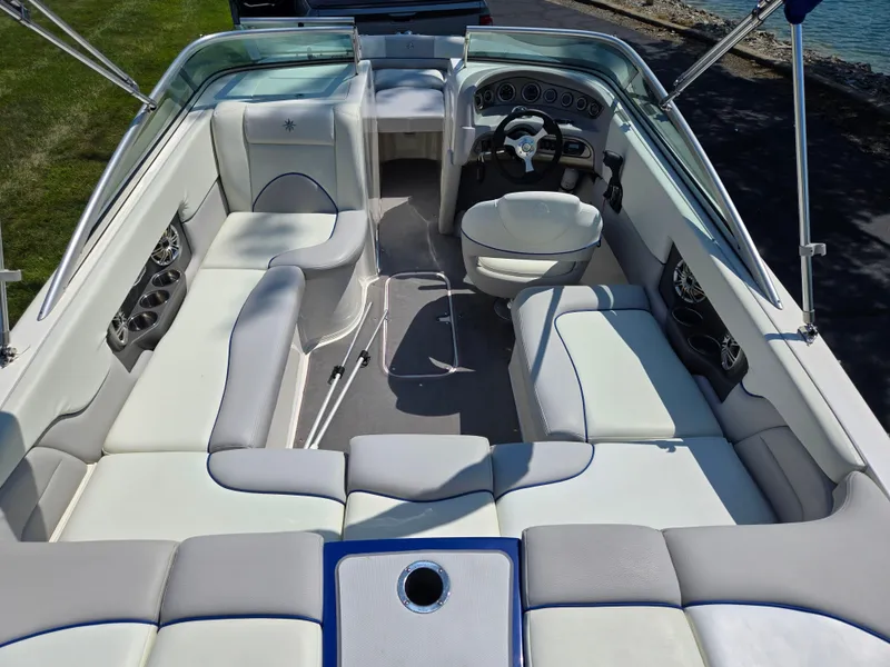 Slide: The Image of 2013 Bryant 210 STE boat interior with white seating and modern dashboard. - 10