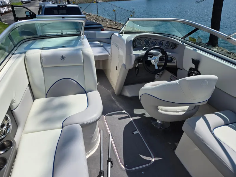 Slide: The Image of Interior of a 2013 Bryant 210 STE boat with white seating and steering wheel. - 11