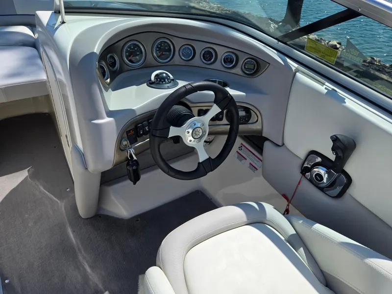 Slide: The Image of 2013 Bryant 210 STE boat dashboard with steering wheel and control panel. - 13