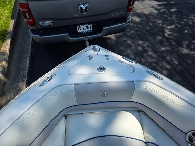 Slide: The Image of 2013 Bryant 210 STE boat hitched to a truck, parked on a shaded street. - 17