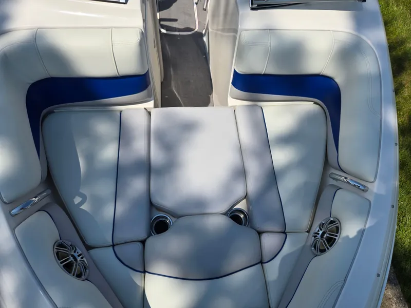 Slide: The Image of 2013 Bryant 210 STE boat interior with white and blue cushioned seating. - 18