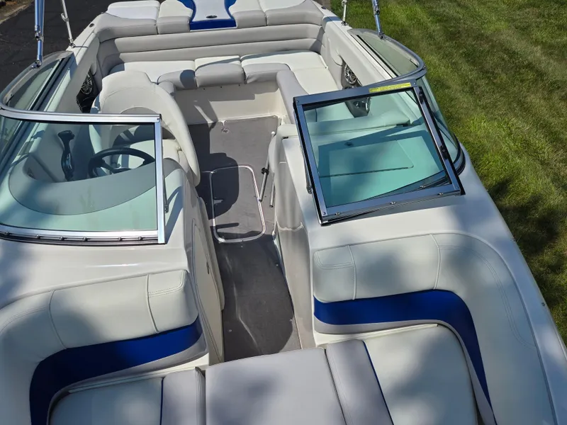 Slide: The Image of 2013 Bryant 210 STE boat interior with open windshield and plush seating. - 19