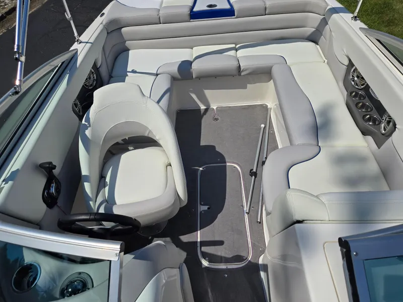 Slide: The Image of Interior of a 2013 Bryant 210 STE boat with white seating and steering wheel. - 20