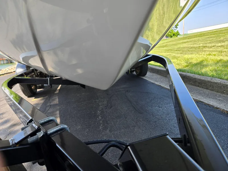 Slide: The Image of Close-up of a 2013 Bryant 210 STE boat on a trailer, parked on asphalt. - 7