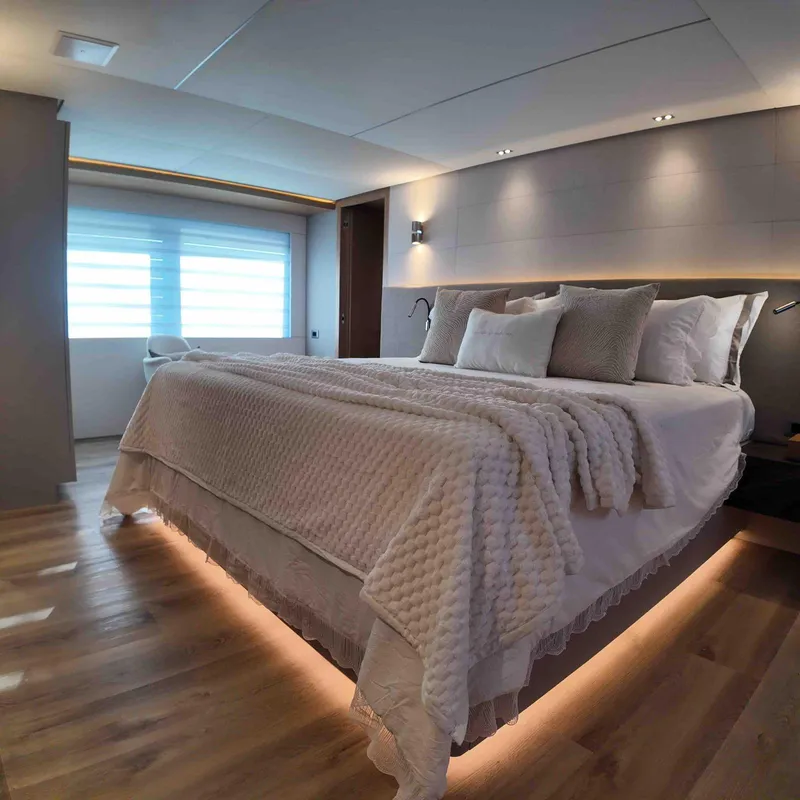 Slide: The Image of Luxurious bedroom interior on Inace AVENTURA 106 yacht, 2027 model, featuring elegant lighting and cozy bedding. - 13