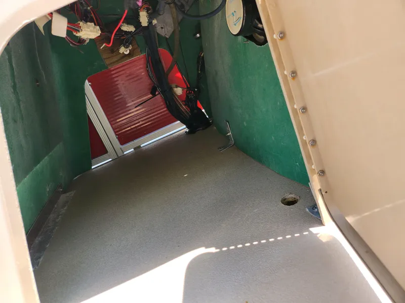 Slide: The Image of Interior view of a 2012 Bennington 22 SSL boat, showing wiring and storage space. - 14