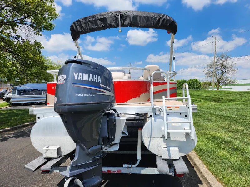 Slide: The Image of 2012 Bennington 22 SSL pontoon boat with Yamaha outboard motor, parked on a sunny day. - 2