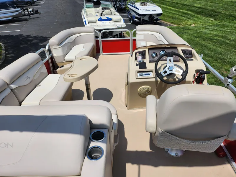 Slide: The Image of 2012 Bennington 22 SSL pontoon boat interior with beige seating and steering console. - 21
