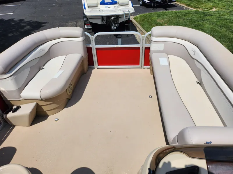 Slide: The Image of 2012 Bennington 22 SSL pontoon boat interior with beige seating and red panel. - 24
