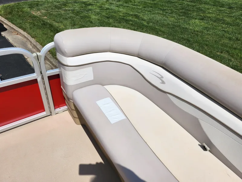 Slide: The Image of 2012 Bennington 22 SSL boat interior with beige seating and red paneling. - 25