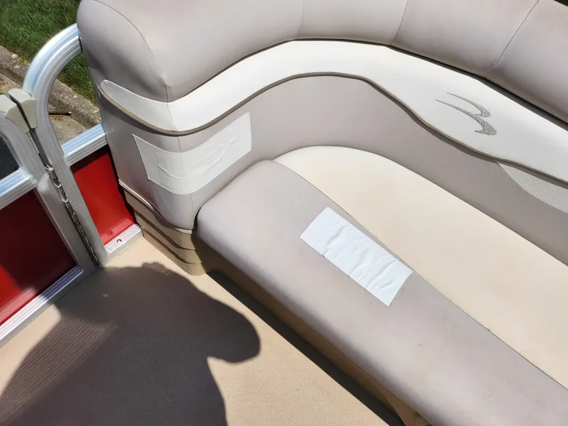 Slide: The Image of 2012 Bennington 22 SSL boat interior with beige seating and red accents. - 26