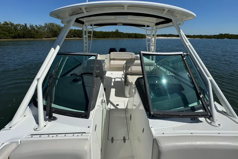 Slide: The Image of 2017 Boston Whaler 270 Vantage boat on calm water, featuring open deck and seating. - 15