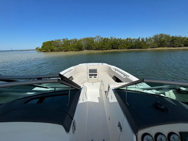 Slide: The Image of 2017 Boston Whaler 270 Vantage on calm water near lush green island. - 17