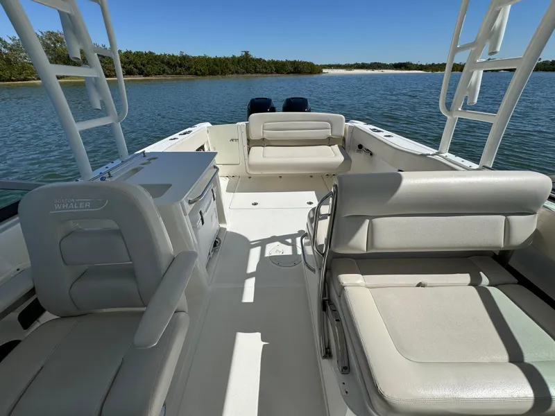 Slide: The Image of 2017 Boston Whaler 270 Vantage boat interior with seating, on calm water. - 19