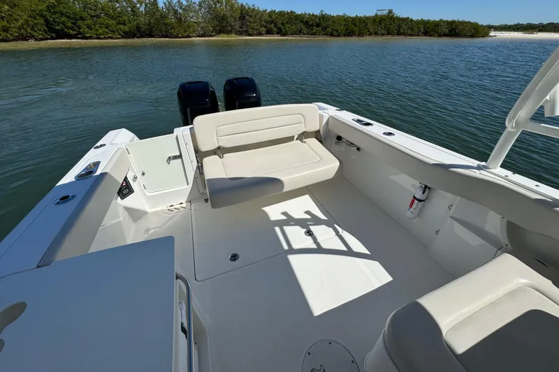 Slide: The Image of 2017 Boston Whaler 270 Vantage boat interior with seating, on calm water. - 25
