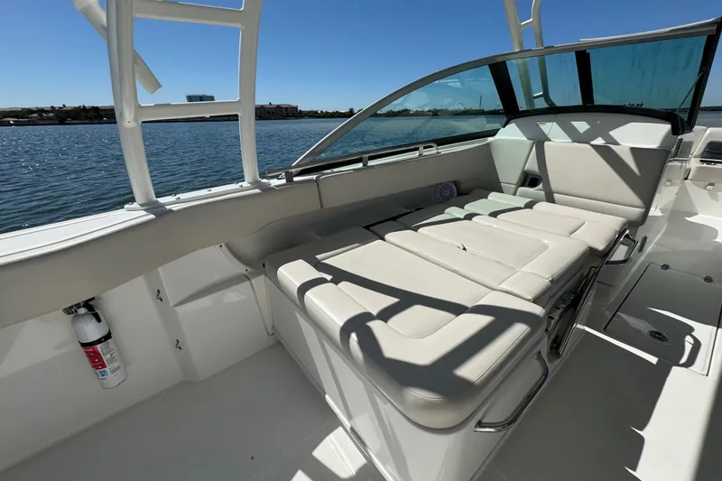 Slide: The Image of 2017 Boston Whaler 270 Vantage boat interior with cushioned seating and waterfront view. - 31
