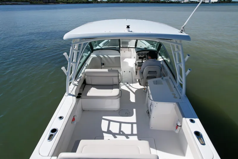 Slide: The Image of 2017 Boston Whaler 270 Vantage boat interior with seating and helm on calm water. - 9