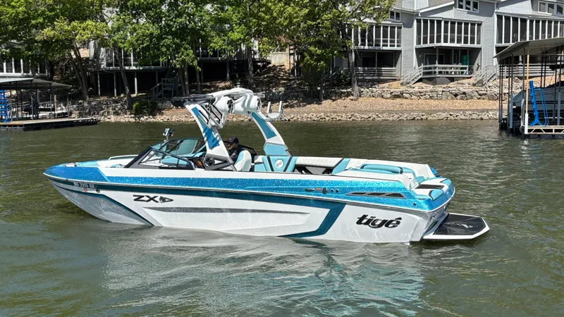 Slide: The Image of 2019 Tigé 25 ZXS boat on a lake, near waterfront homes. - 10