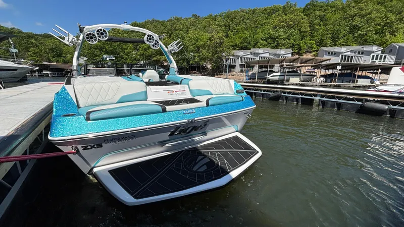 Slide: The Image of 2019 Tigé 25 ZXS boat docked at a marina, surrounded by water and lush greenery. - 12