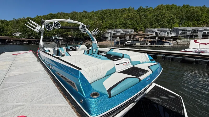 Slide: The Image of 2019 Tigé 25 ZXS boat docked, featuring sleek design and vibrant blue color. - 13