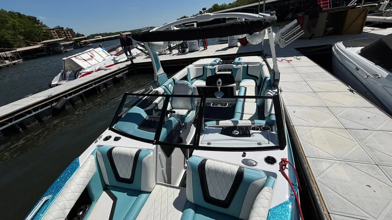 Slide: The Image of 2019 Tigé 25 ZXS boat docked, featuring stylish seating and sleek design. - 17