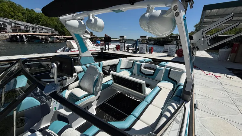 Slide: The Image of 2019 Tigé 25 ZXS boat interior with modern seating at a dock. - 19