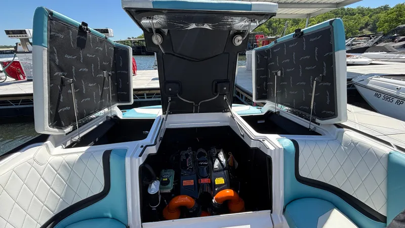 Slide: The Image of 2019 Tigé 25 ZXS boat engine compartment with open hatches at a marina. - 22