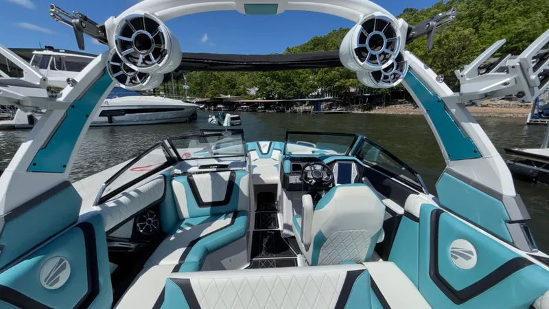 Slide: The Image of 2019 Tigé 25 ZXS boat interior with modern design and teal accents on a sunny day. - 27