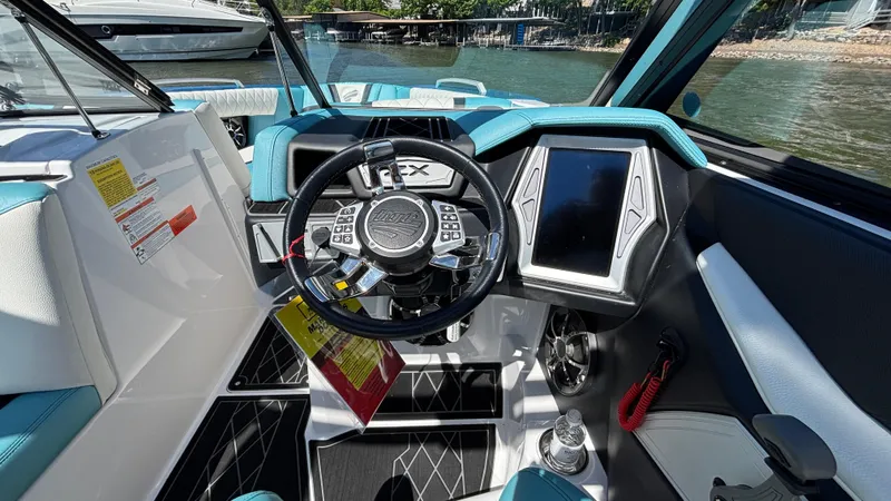 Slide: The Image of 2019 Tigé 25 ZXS boat dashboard with steering wheel and touchscreen display. - 30