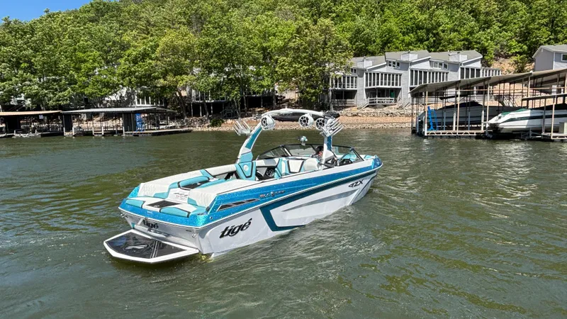 Slide: The Image of 2019 Tigé 25 ZXS boat on a lake near modern lakeside homes. - 4