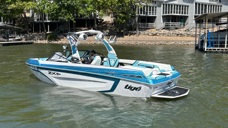 Slide: The Image of 2019 Tigé 25 ZXS boat on a lake, featuring sleek design and vibrant blue accents. - 8