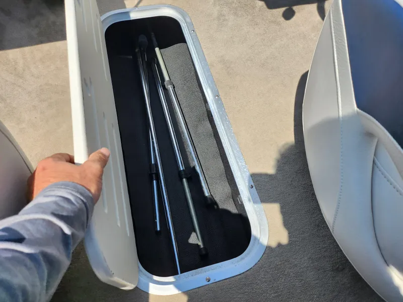 Slide: The Image of Storage compartment in a 2008 Crownline 180 BR boat, containing metal rods. - 12