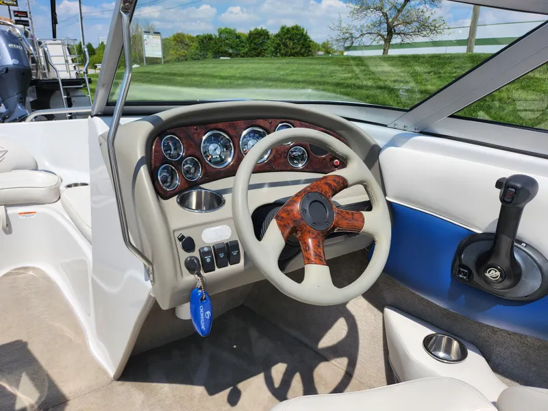 Slide: The Image of 2008 Crownline 180 BR boat dashboard with wood-accented steering wheel and instrument panel. - 13
