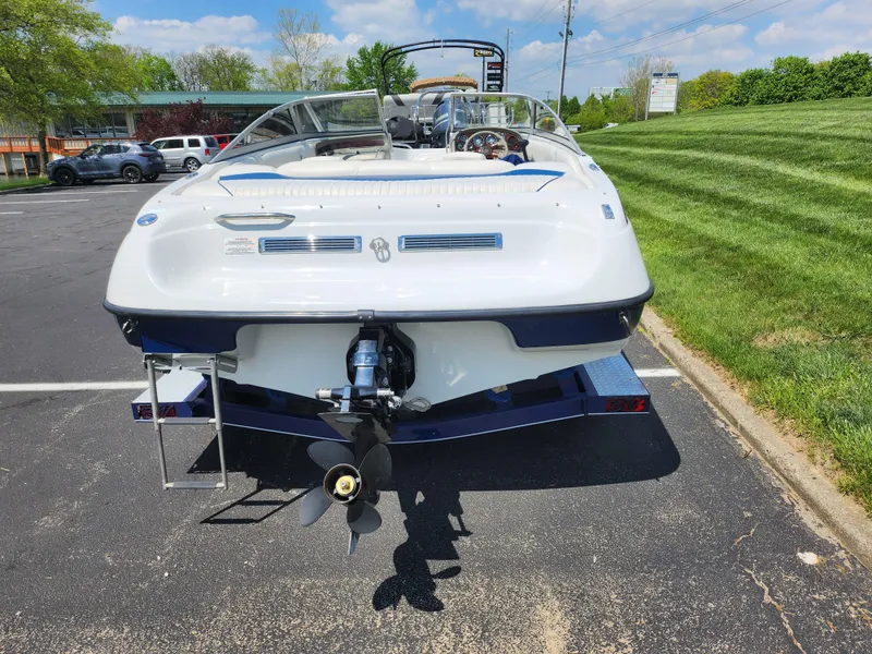 Slide: The Image of 2008 Crownline 180 BR boat, rear view, parked on pavement near grassy area. - 2