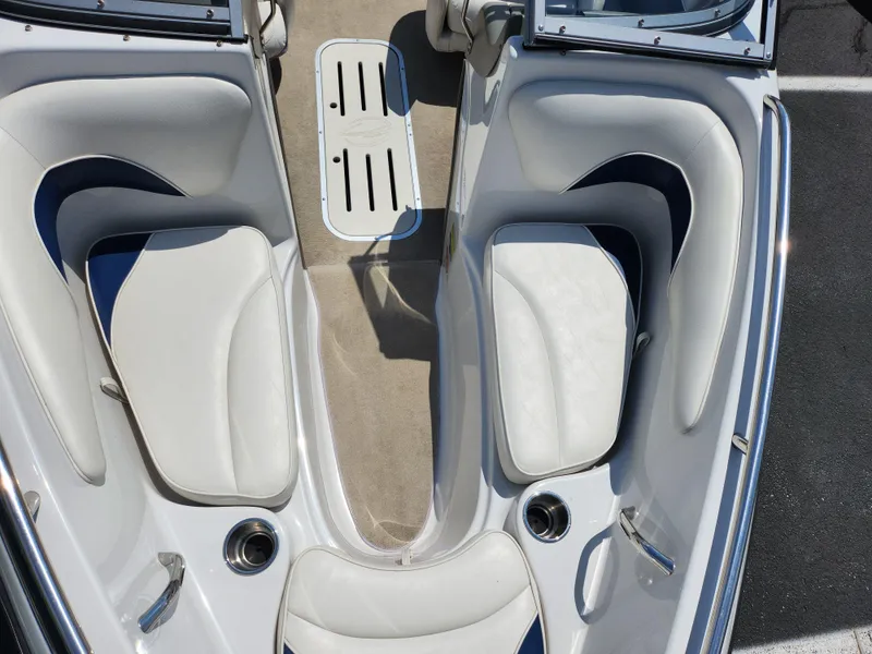 Slide: The Image of 2008 Crownline 180 BR boat interior with white seating and beige flooring. - 20