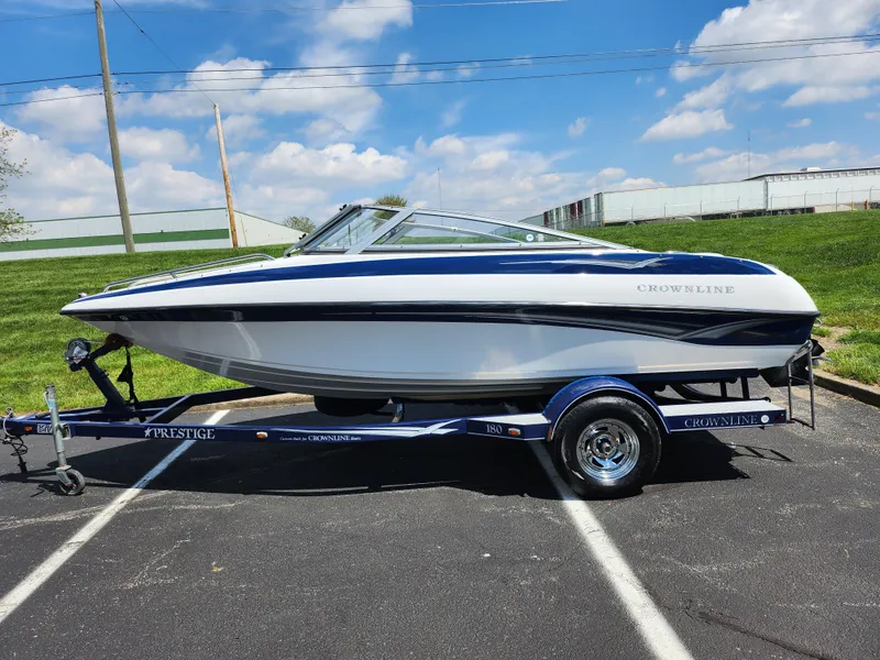 Slide: The Image of 2008 Crownline 180 BR boat on trailer, parked outdoors under a blue sky. - 4