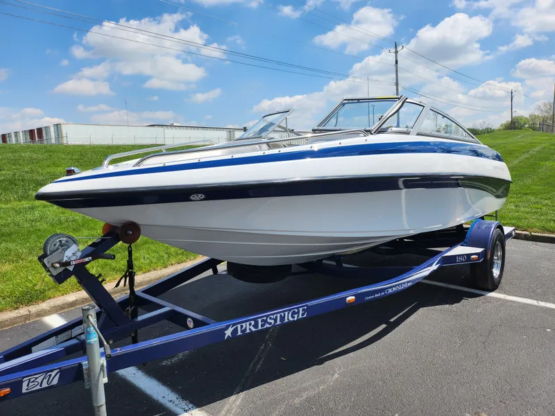 Slide: The Image of 2008 Crownline 180 BR boat on a Prestige trailer, parked outdoors under a blue sky. - 5