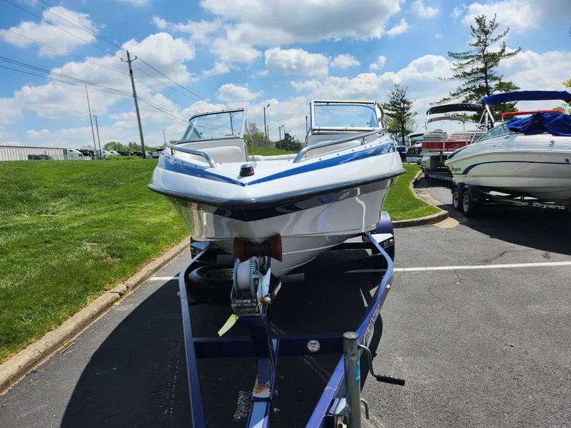 Slide: The Image of 2008 Crownline 180 BR boat on trailer, parked outdoors under a blue sky. - 6